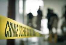 Crime scene tape with investigators in the background