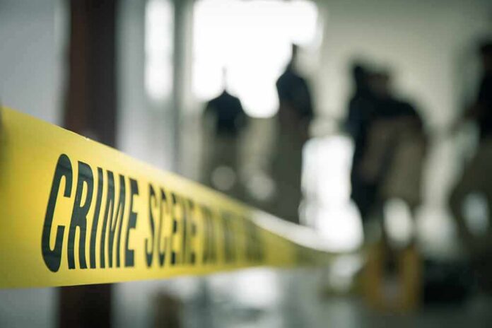 Crime scene tape with investigators in the background