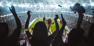 Fans cheering in a packed stadium during a night game