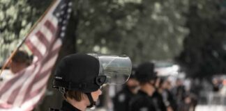 police officer in riot gear standing in a line