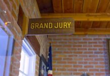 Vegas Hotel Horror: Flamingo Dragged, Verdict In Grand jury sign in a brick-walled hallway