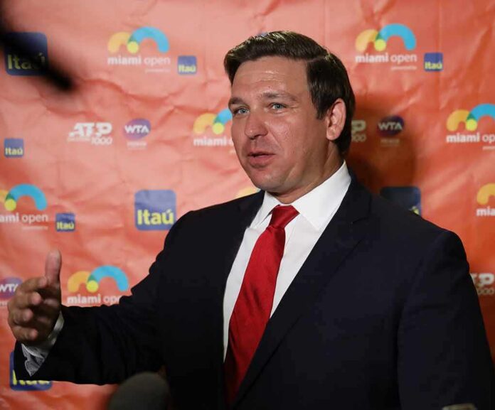 man in suit speaking at event backdrop