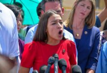 Judy Chu among crowd as a woman in red speaks at outdoor press event
