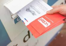 Election Shock: USPS Rule Gets Hammered Hand dropping mail-in ballots into a drop box