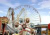 Ride Malfunction or Negligence? Colorful amusement park scene featuring a ferris wheel and carousel
