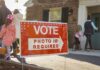 Troops At Polls? Pentagon Says Nope Red voting sign with arrow near people entering a polling place