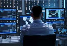 IT professional monitors multiple screens in a server room