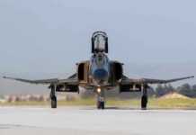 Military jet taxiing on runway with open canopy